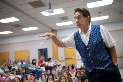 Jim speaks in front of a crowd of children at a public library