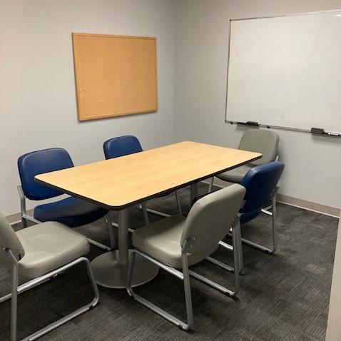 small room with six chairs and a table