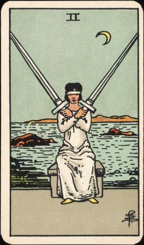 The two of swords Tarot card.  Pictured is a woman with a blindfold holding two swords.