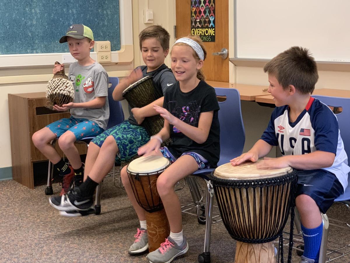 4 children playing African drums