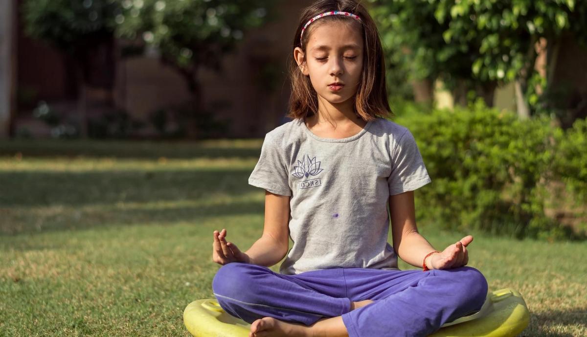 girl sitting cross-legged on a yoga mat