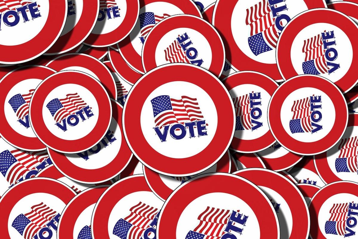 A pile of pins that each show an American flag and the word Vote.